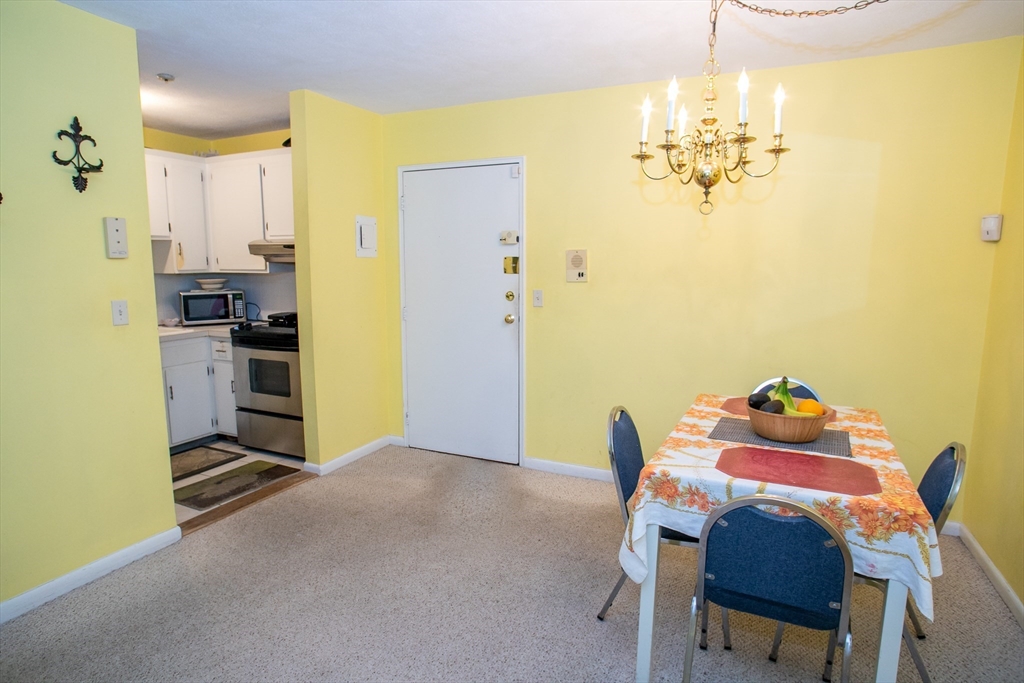 110 Boston Post Road East, Unit 104 Marlborough, MA 01752 - Photo 4 of 28 a view of a dining room with furniture and chandelier