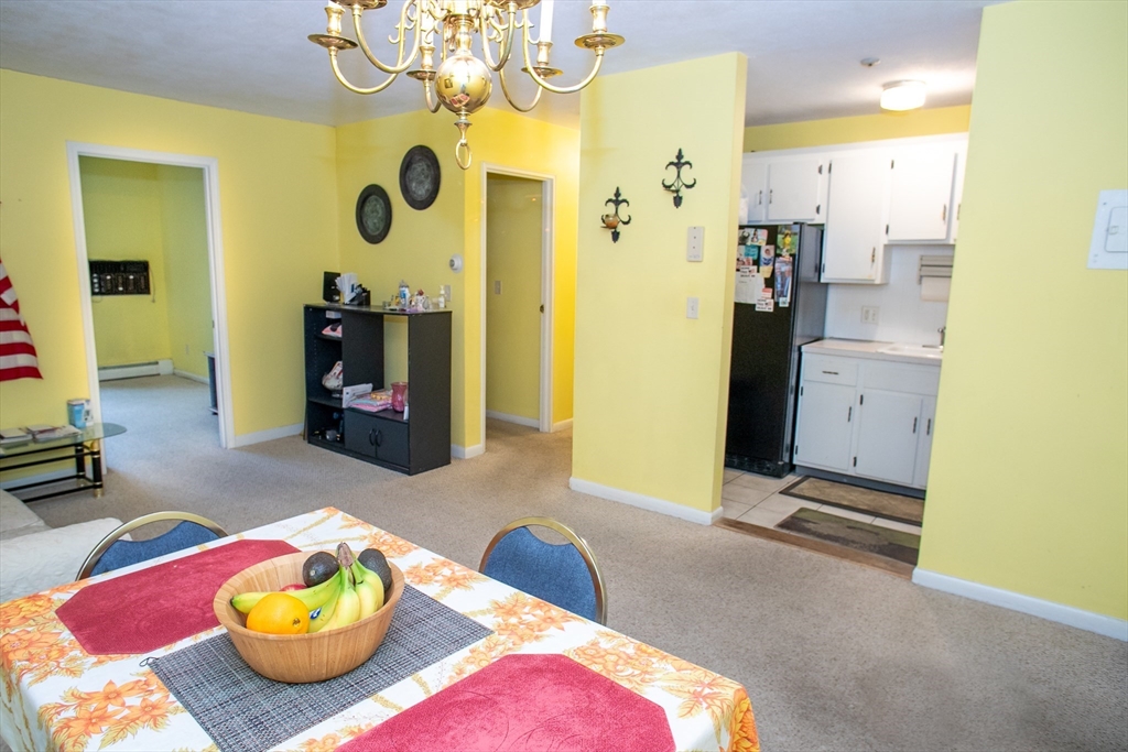 110 Boston Post Road East, Unit 104 Marlborough, MA 01752 - Photo 6 of 28 a bedroom with a bed and a chandelier