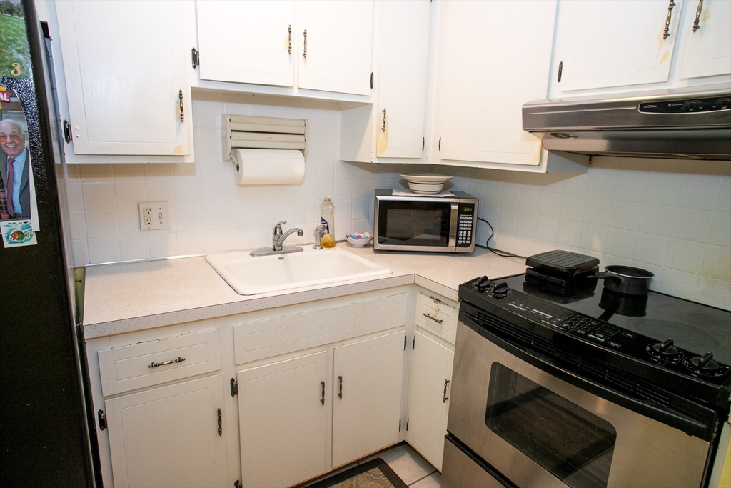 110 Boston Post Road East, Unit 104 Marlborough, MA 01752 - Photo 7 of 28 a kitchen with a sink stove and cabinets