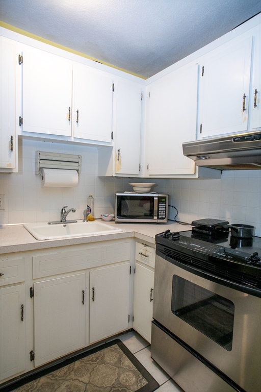 110 Boston Post Road East, Unit 104 Marlborough, MA 01752 - Photo 8 of 28 a kitchen with white cabinets and appliances