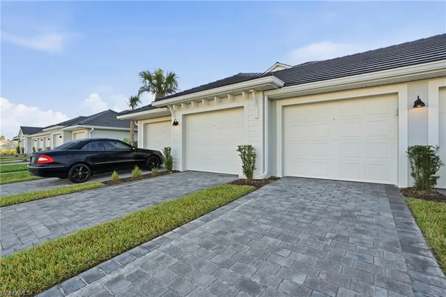 a front view of a house with a garden and parking