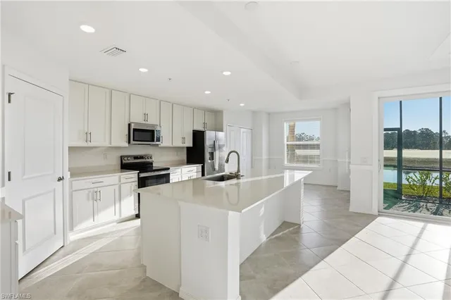 a kitchen with white cabinets and appliances