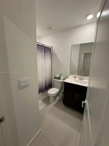 a bathroom with a double vanity sink toilet and mirror