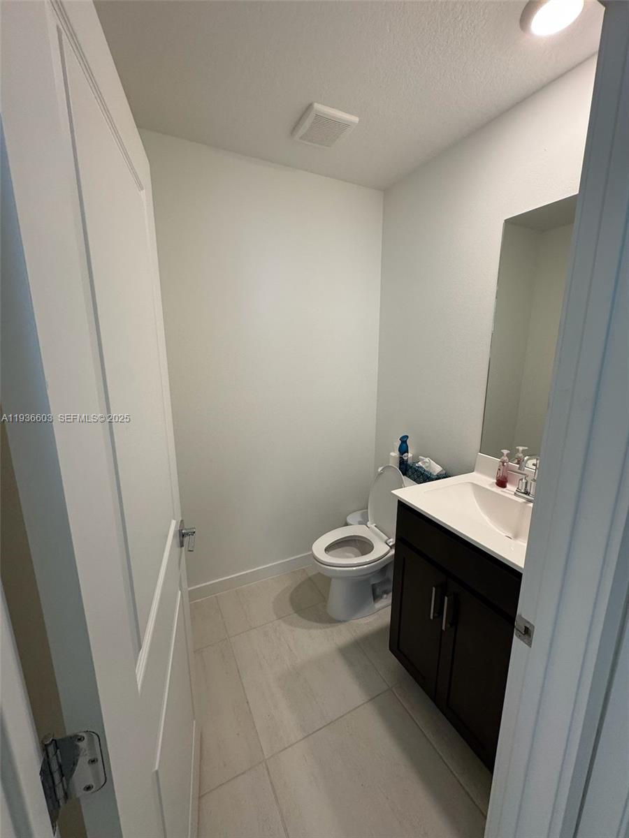 141 Northeast 13th Circle Homestead, FL 33033 - Photo 12 of 19 a bathroom with a sink a toilet and a mirror