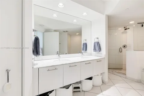 a spacious bathroom with a double vanity sink a mirror and a toilet