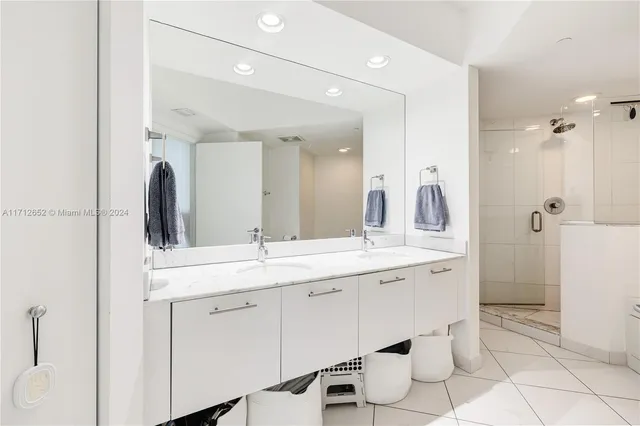 a spacious bathroom with a double vanity sink a mirror and a toilet