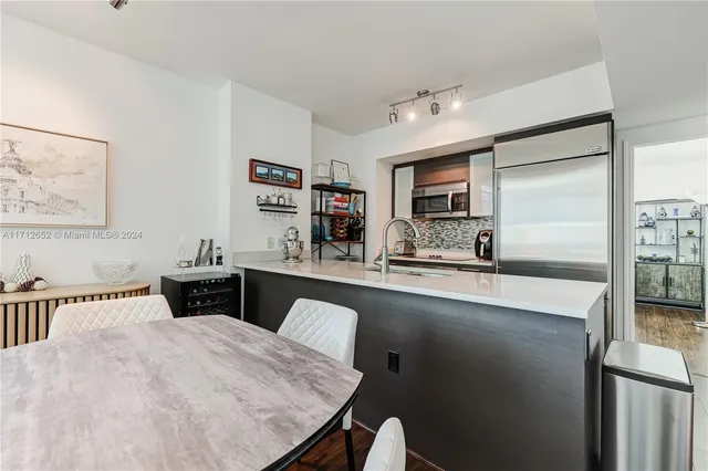 a kitchen with stainless steel appliances granite countertop a sink and a refrigerator