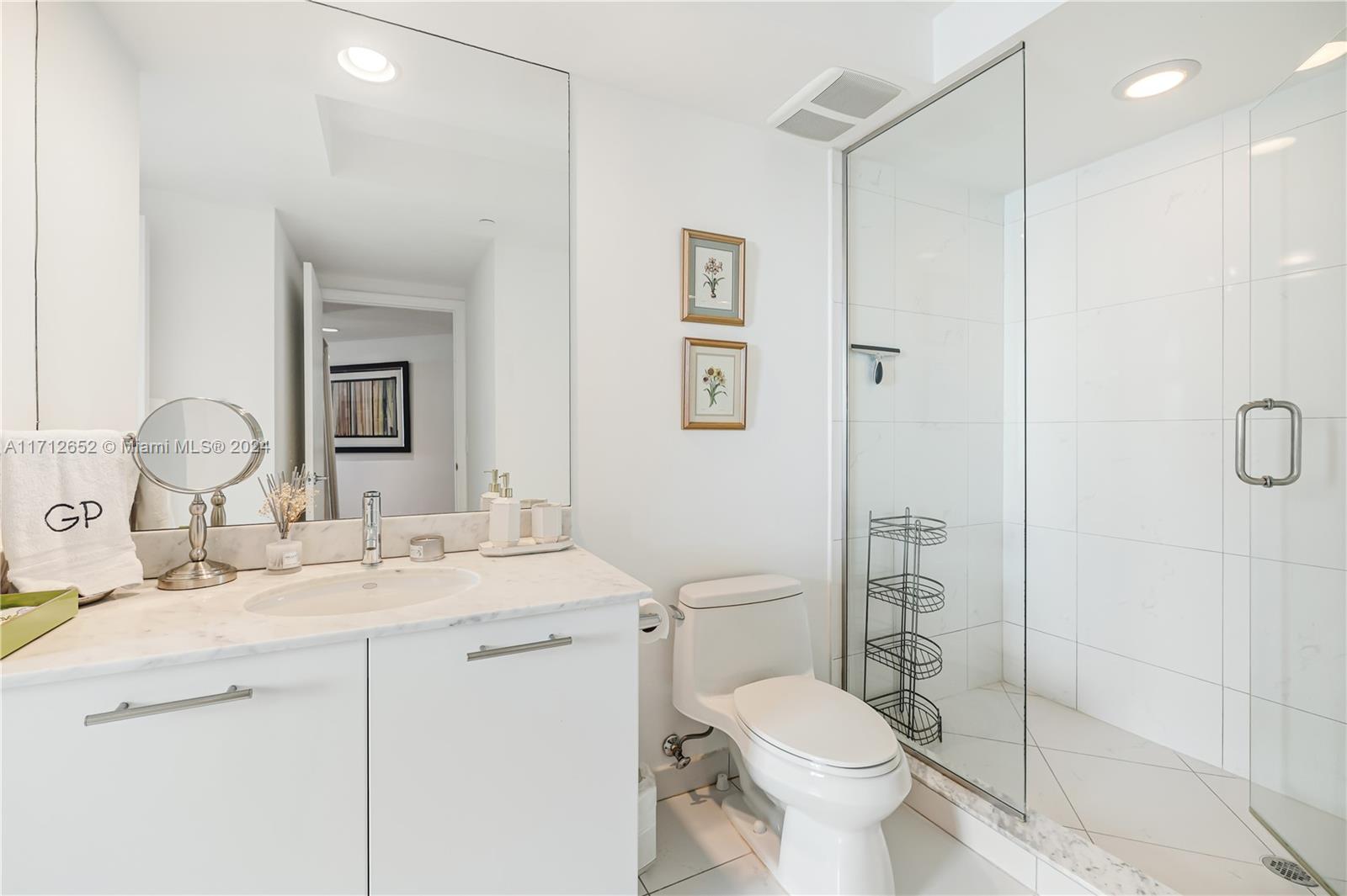 55 Southeast 6th Street, Unit 3407 Miami, FL 33131 - Photo 20 of 33 a bathroom with a granite countertop sink toilet and shower