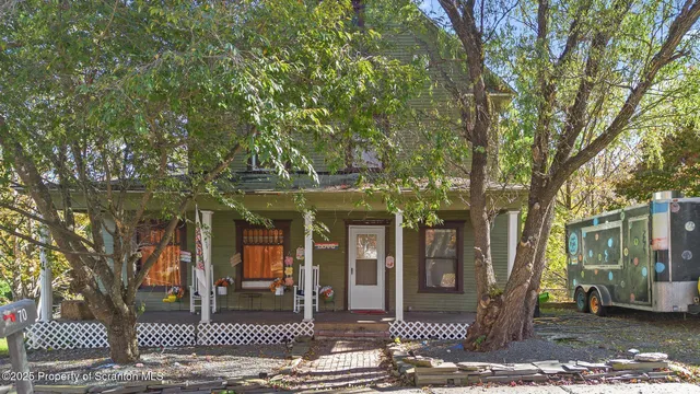a front view of a house with a tree