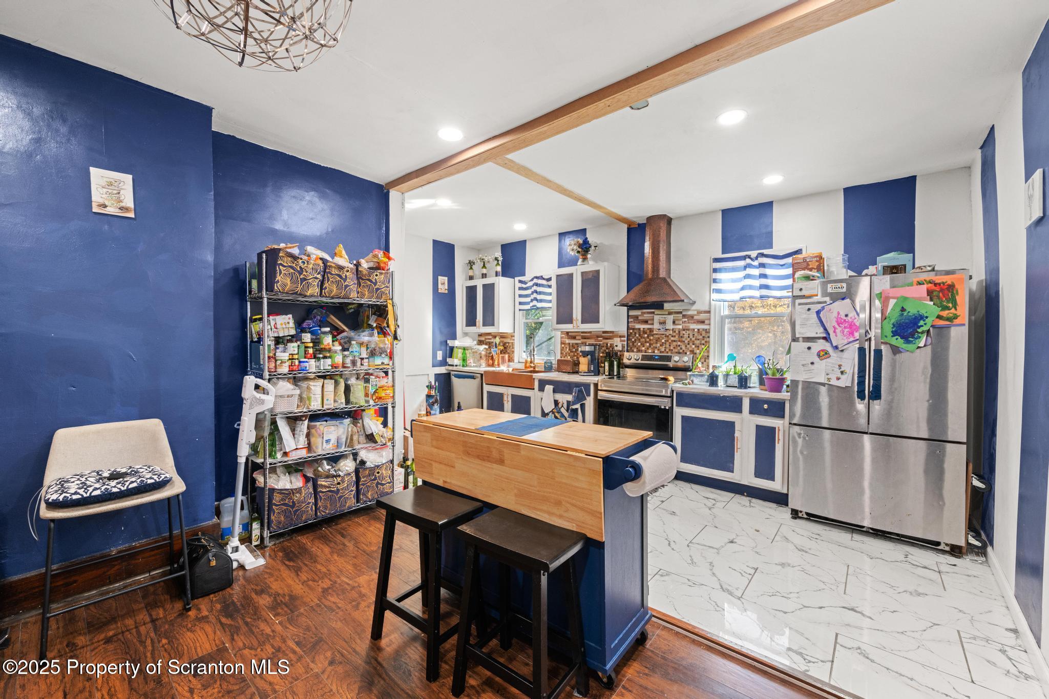 70 State Street Nicholson, PA 18446 - Photo 19 of 64 a kitchen with stainless steel appliances granite countertop a refrigerator oven stove a dining table and chairs with wooden floor