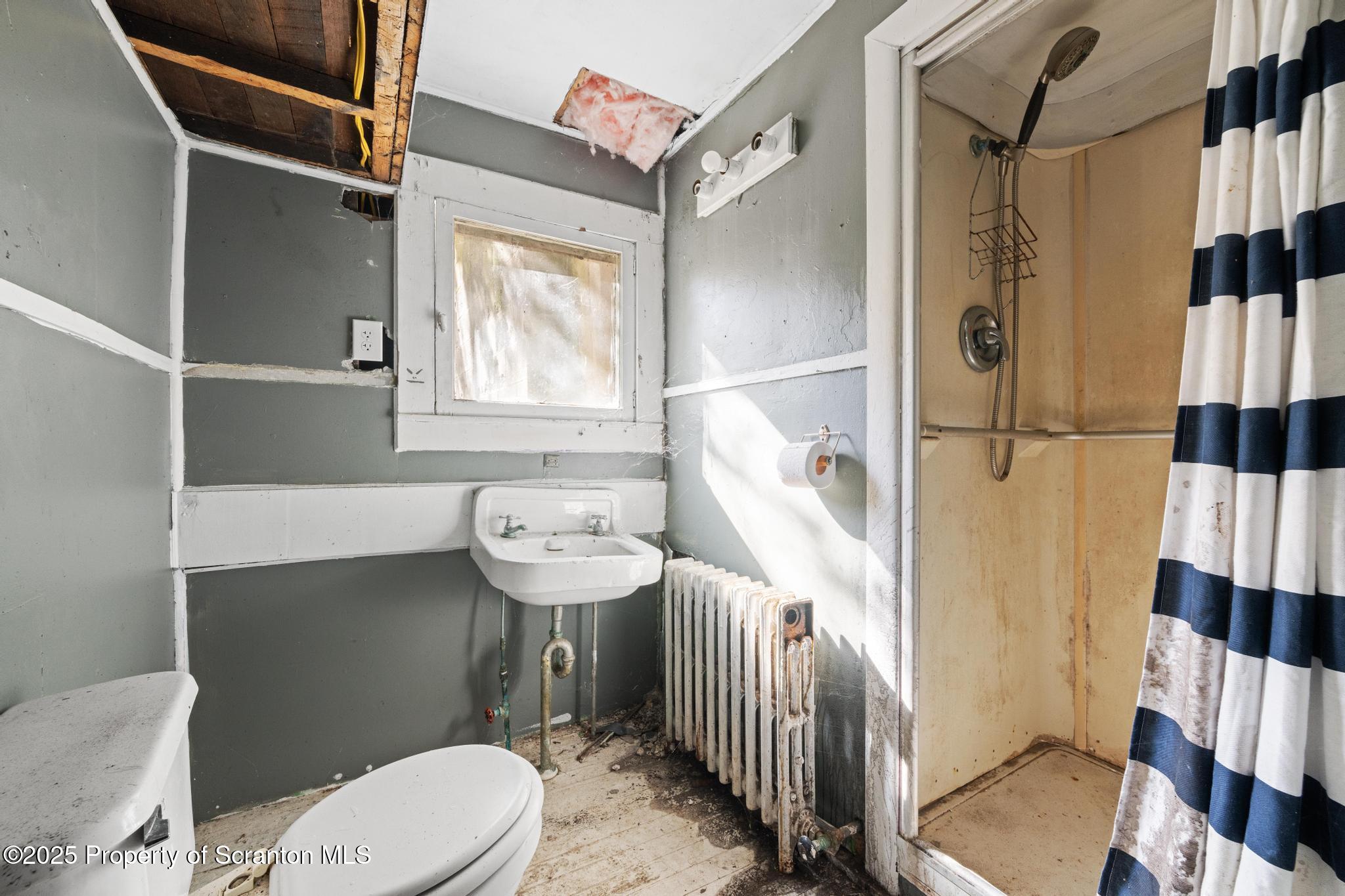 70 State Street Nicholson, PA 18446 - Photo 46 of 64 a bathroom with a sink a toilet a window and shower