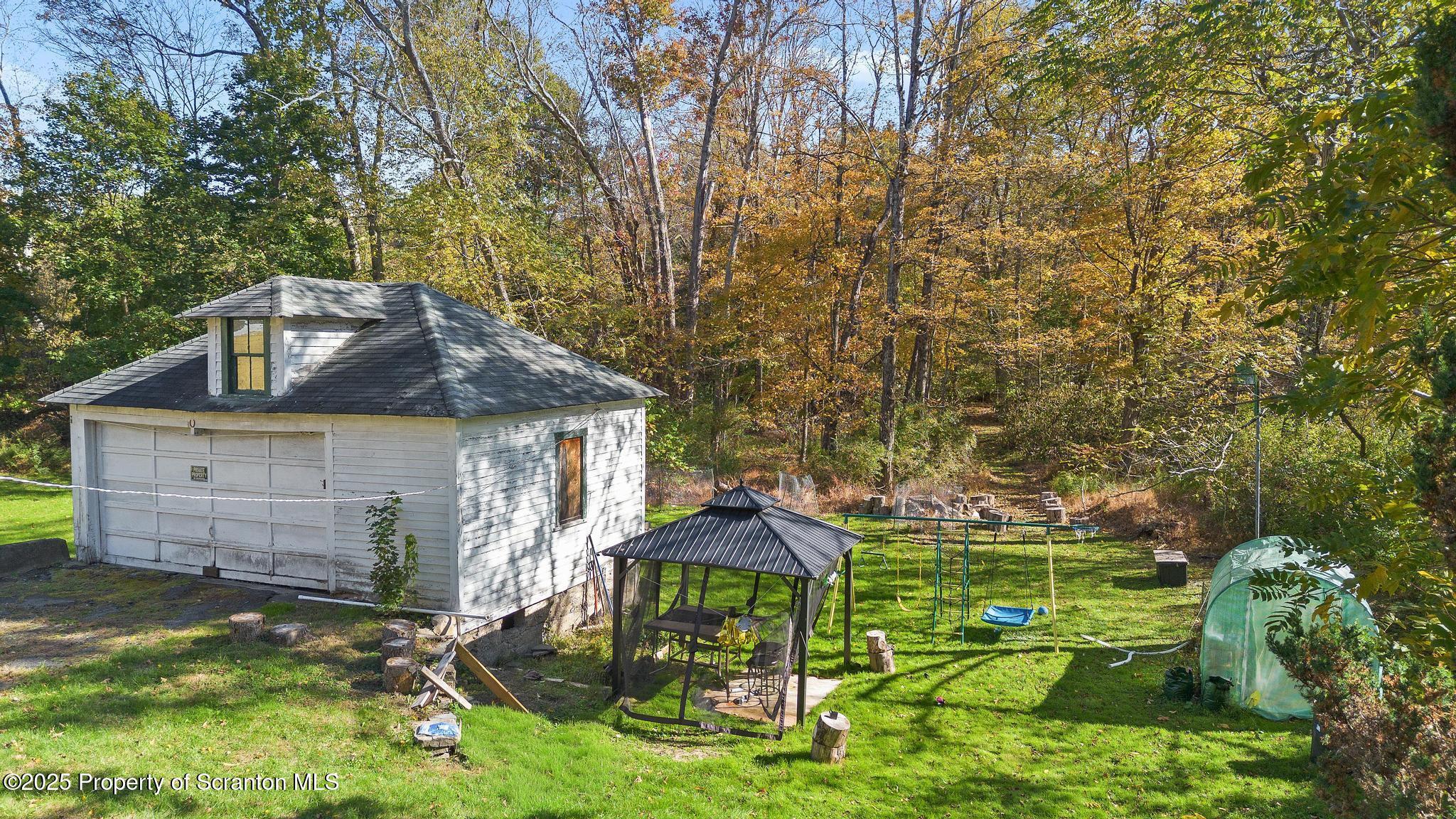 70 State Street Nicholson, PA 18446 - Photo 57 of 64 a backyard of a house with table and chairs under an umbrella