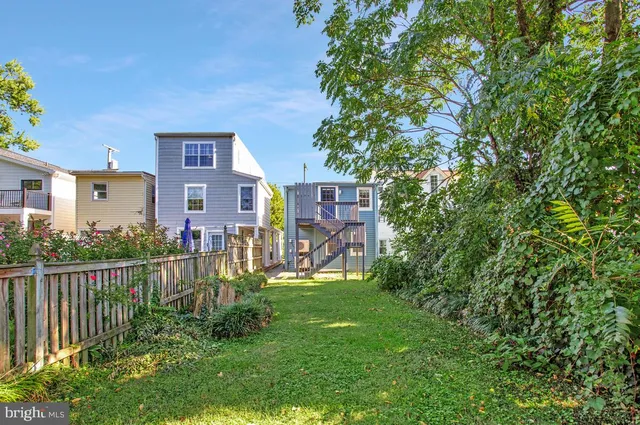 a view of a brick house with a yard and plants
