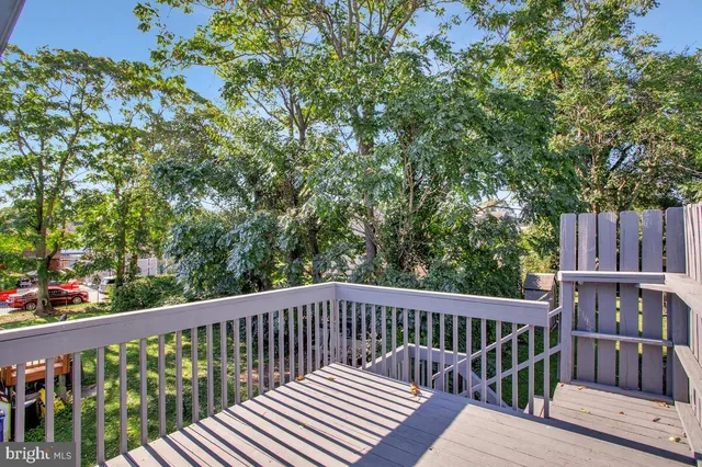a view of balcony with wooden fence and trees
