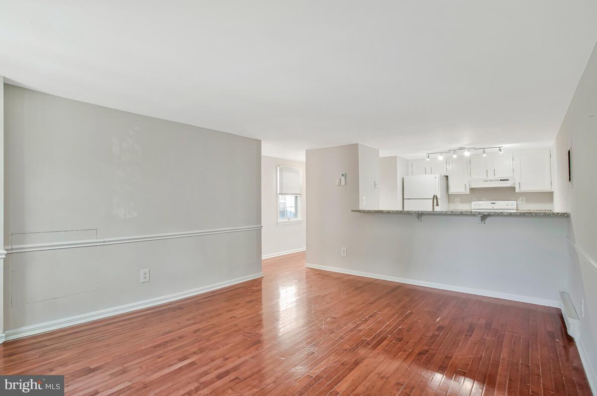 320 Chester Avenue Annapolis, MD 21403 - Photo 20 of 32 a view of an empty room with wooden floor and kitchen