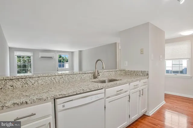 a kitchen with granite countertop white cabinets and a window