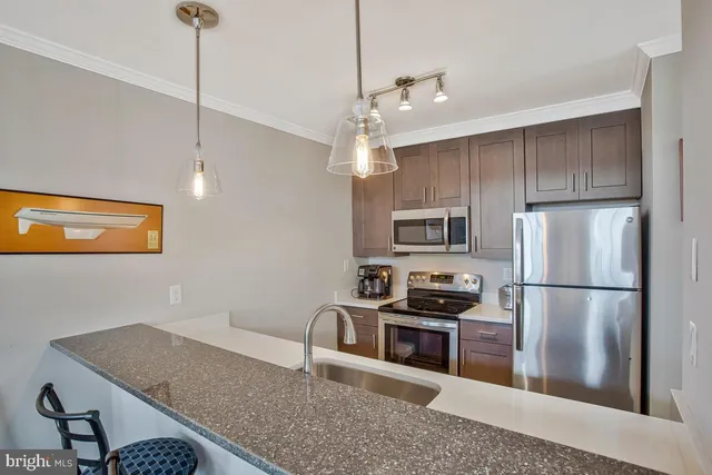a kitchen with a refrigerator a stove a sink and white cabinets