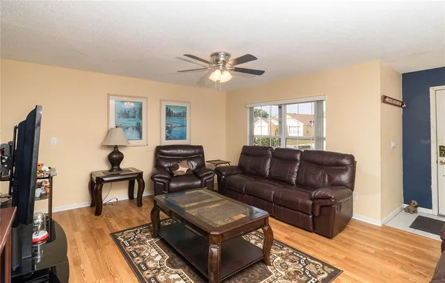 a living room with furniture a ceiling fan and a window