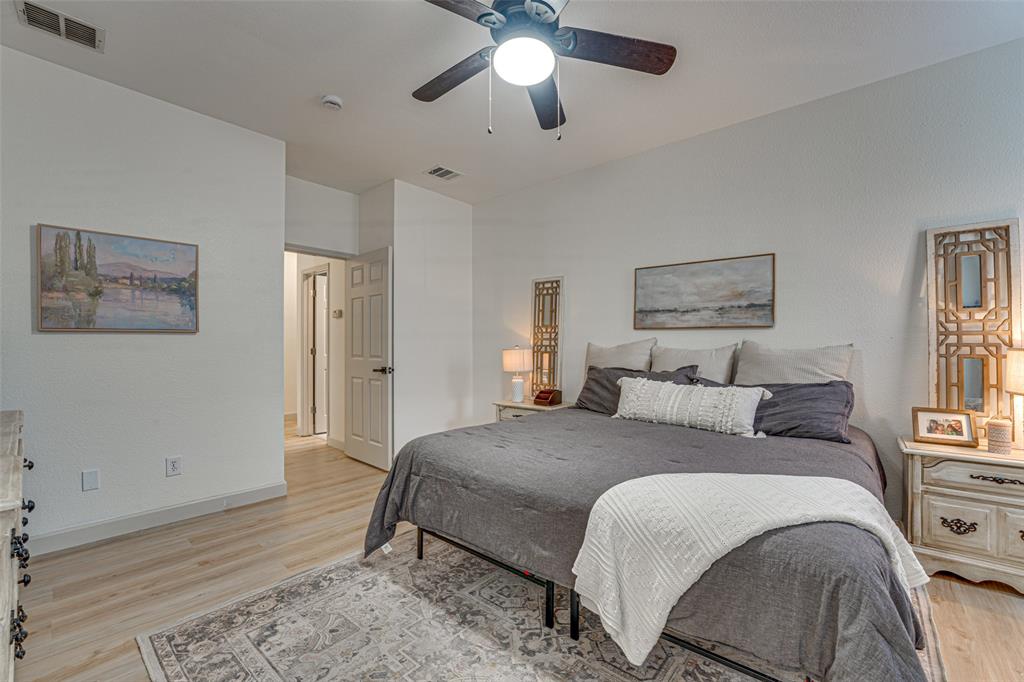 5218 Griffins Pointe Drive Rowlett, TX 75089 - Photo 15 of 40 Primary bedroom on first level with recent laminate flooring and barn door.