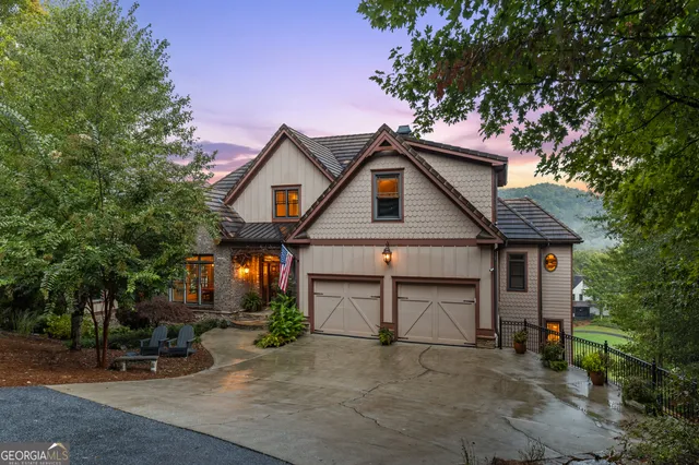 a view of a house with a yard and large tree