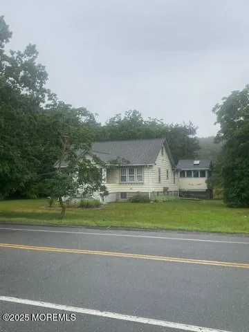 a front view of a house with a yard and trees