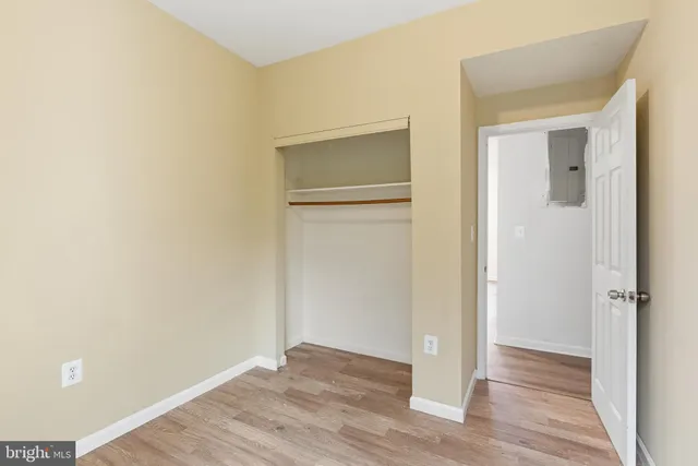 an empty room with wooden floor and closet