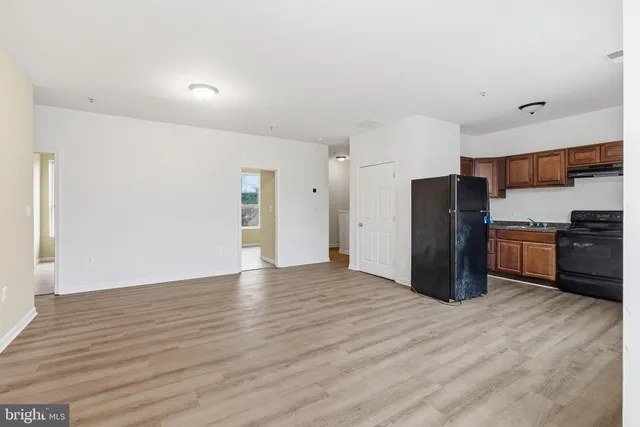 a view of kitchen with stainless steel appliances wooden cabinets and a refrigerator