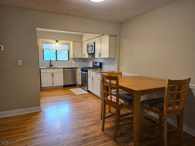 a kitchen with granite countertop wooden floors and wooden cabinets