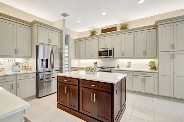 a bedroom with bed and a flat tv screen on dresser