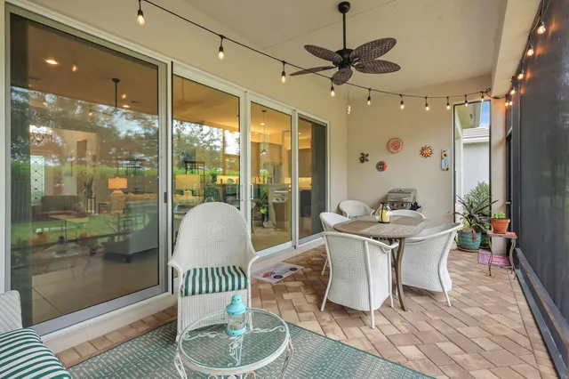 a view of a dining room with furniture a chandelier and window