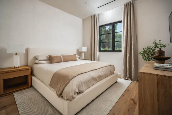 a bedroom with a large bed and a potted plant