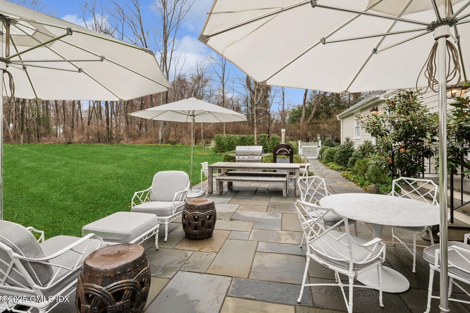 6 Pilgrim Road Darien, CT 06820 - Photo 21 of 23 a view of a patio with table and chairs under an umbrella