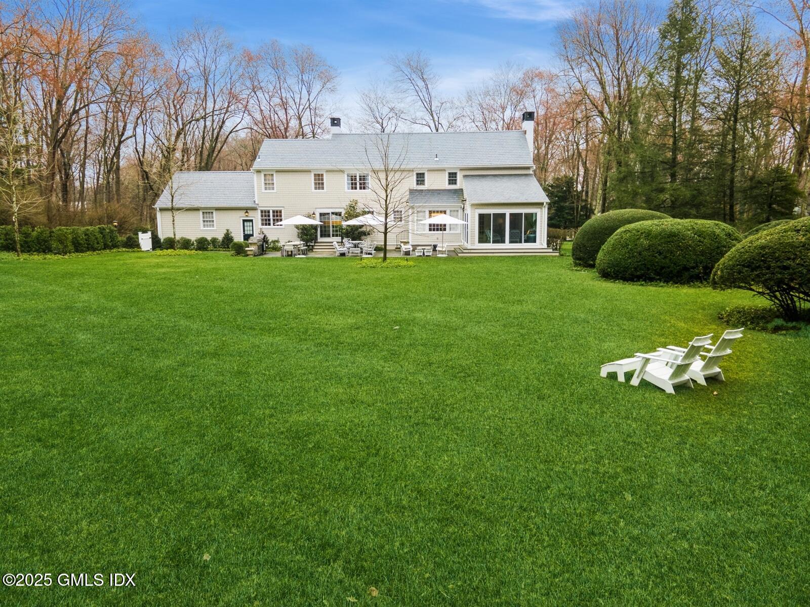 6 Pilgrim Road Darien, CT 06820 - Photo 22 of 23 a front view of a house with a garden and trees
