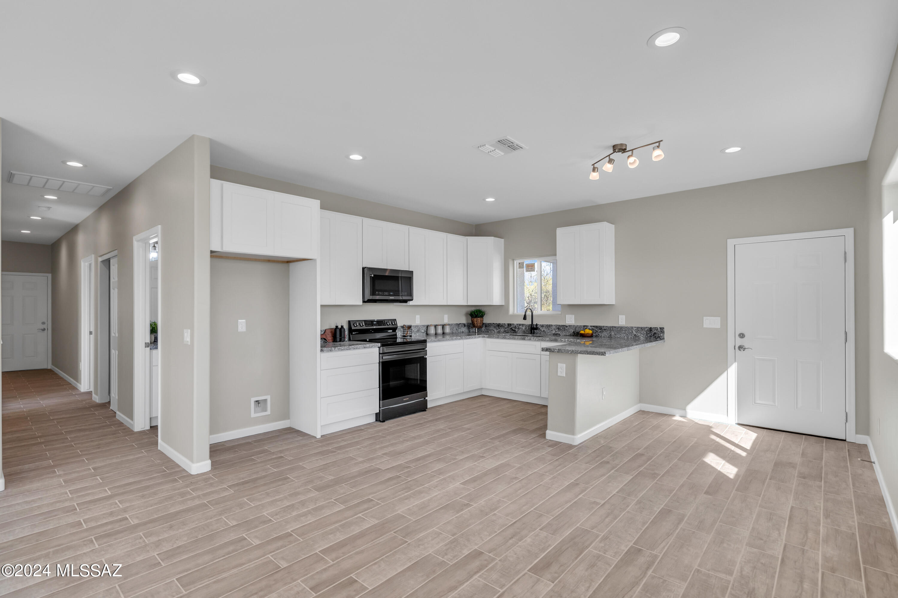 103 Headge Court Rio Rico, AZ 85648 - Photo 5 of 35 a large kitchen with stainless steel appliances kitchen island granite countertop a stove a sink and a refrigerator