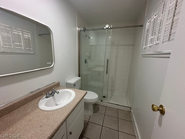 3322 South Pecos Road Las Vegas, NV 89121 - Photo 12 of 16 Tiled flooring and a glass-enclosed walk-in shower anchor this bathroom design.