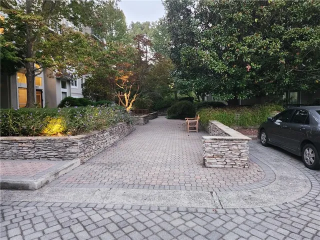 a view of a street with a bench and trees