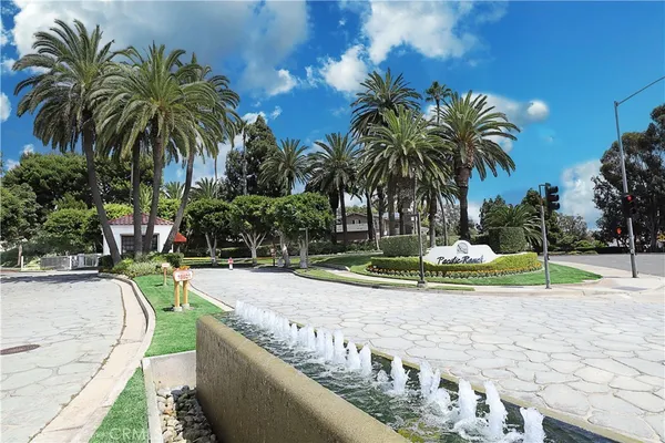 a view of a swimming pool with a patio and palm trees