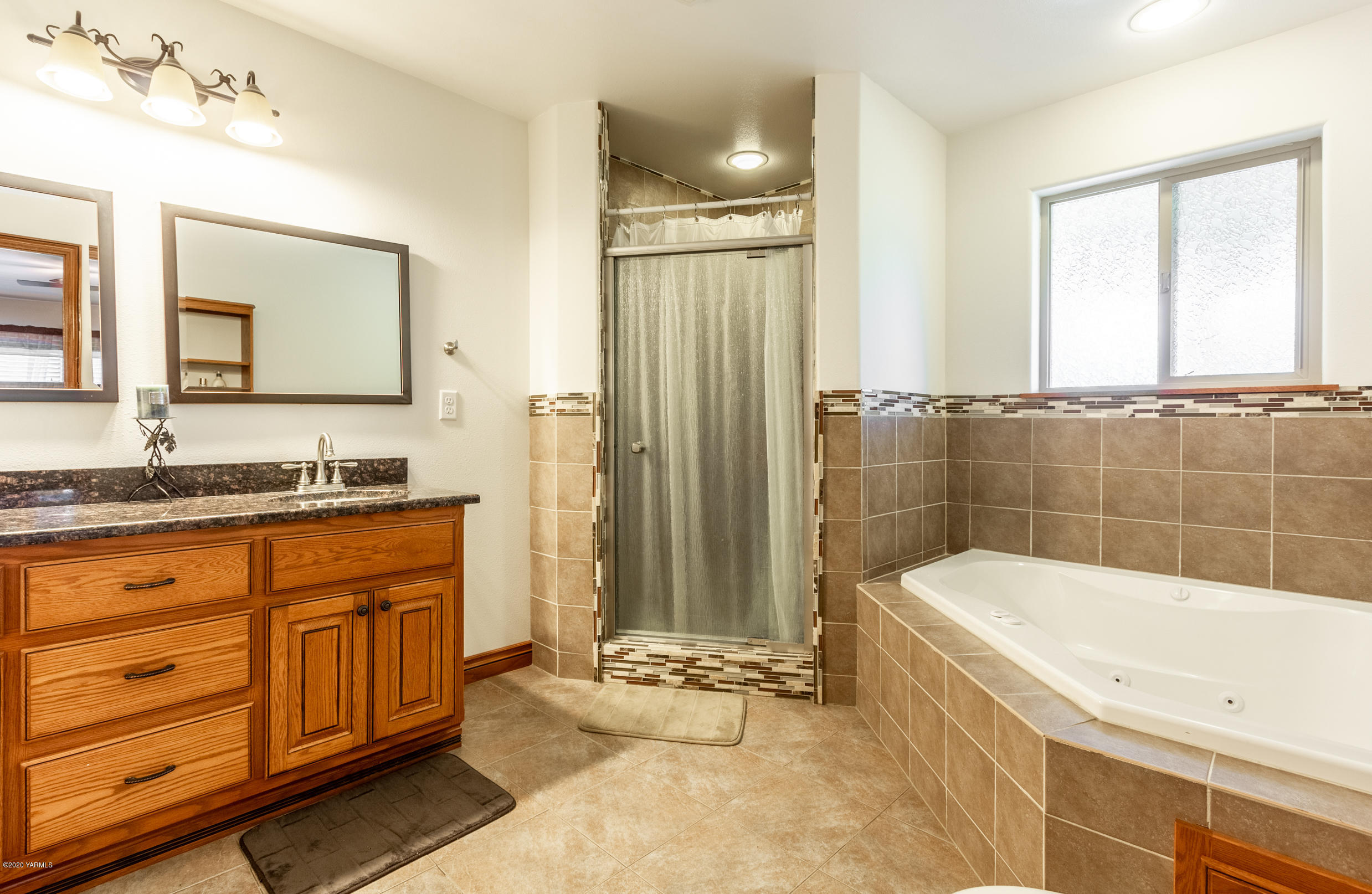 13351 Wide Hollow Road Yakima, WA 98908 - Photo 16 of 31 a bathroom with a granite countertop tub sink a mirror a shower and vanity