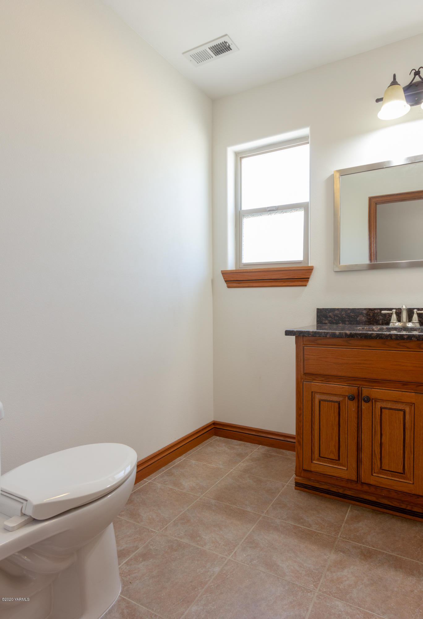 13351 Wide Hollow Road Yakima, WA 98908 - Photo 19 of 31 a bathroom with granite countertop a toilet a sink and a window