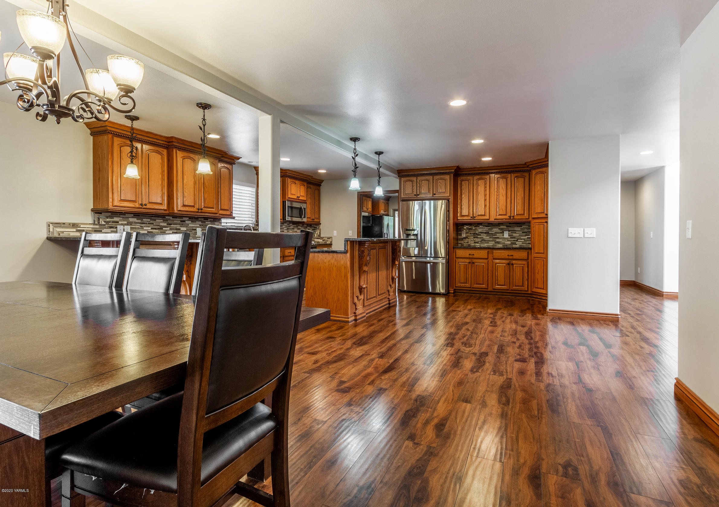 13351 Wide Hollow Road Yakima, WA 98908 - Photo 9 of 31 a view of a dining room and livingroom with furniture wooden floor a chandelier