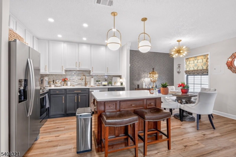400 Daisy Court Jackson, NJ 08527 - Photo 12 of 29 a kitchen with a dining table chairs refrigerator and wooden floor