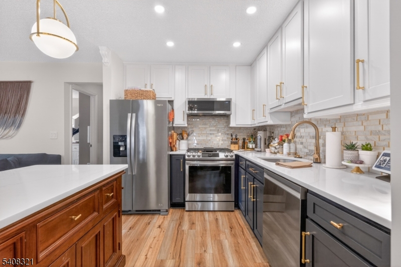 400 Daisy Court Jackson, NJ 08527 - Photo 10 of 29 a kitchen with stainless steel appliances granite countertop a refrigerator a sink dishwasher a stove and white countertops with wooden floor