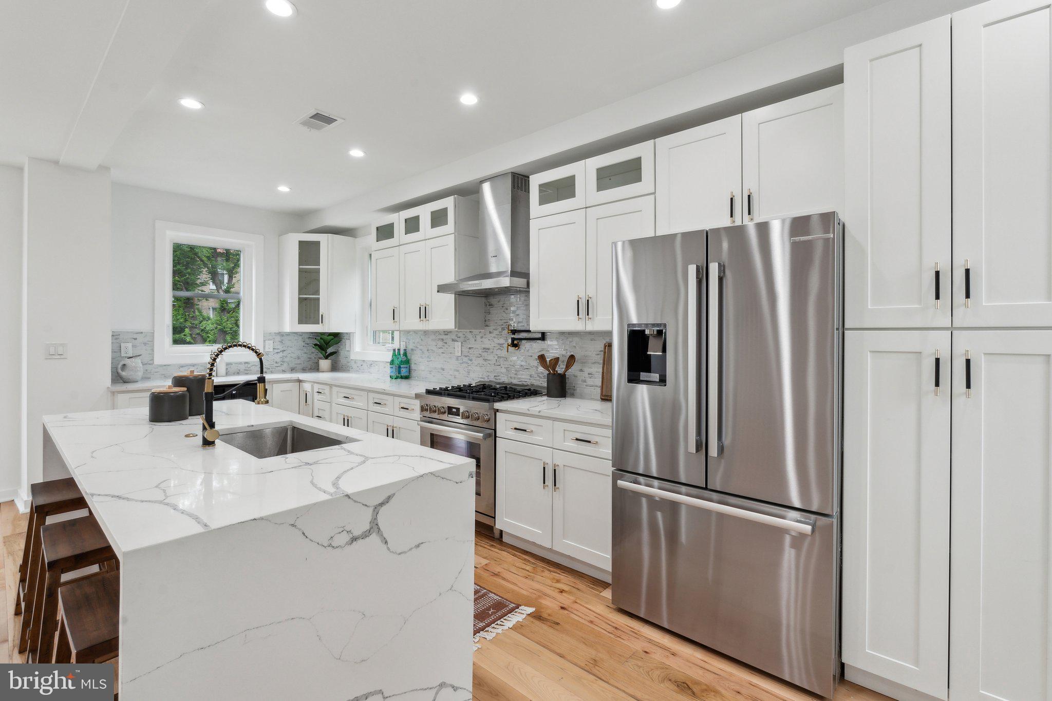 660 Columbia Road Northwest Washington, DC 20001 - Photo 8 of 44 a kitchen with white cabinets and stainless steel appliances