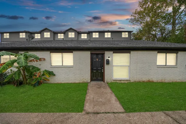 a front view of a house with a garden and plants