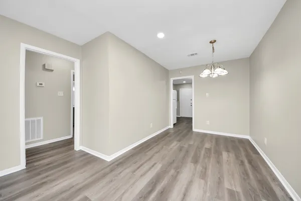 a view of an empty room with wooden floor
