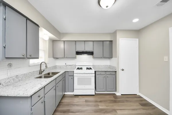 a kitchen with a sink a stove and cabinets
