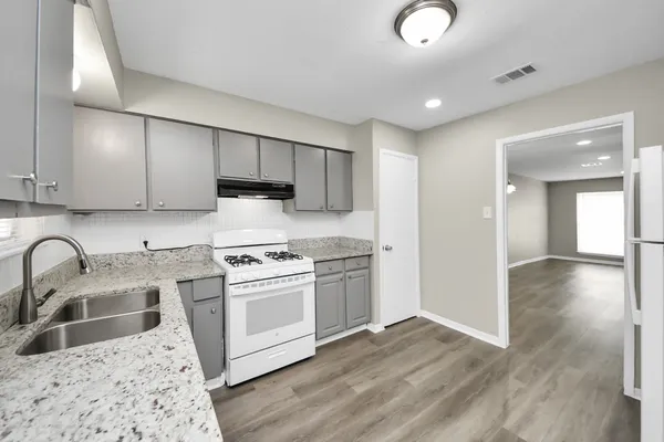 a kitchen with stainless steel appliances granite countertop a sink stove and refrigerator