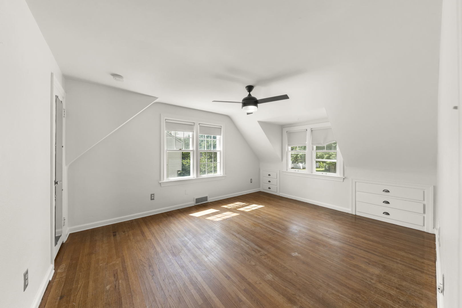1204 Oneida Street Joliet, IL 60435 - Photo 11 of 30 an empty room with wooden floor chandelier fan and windows