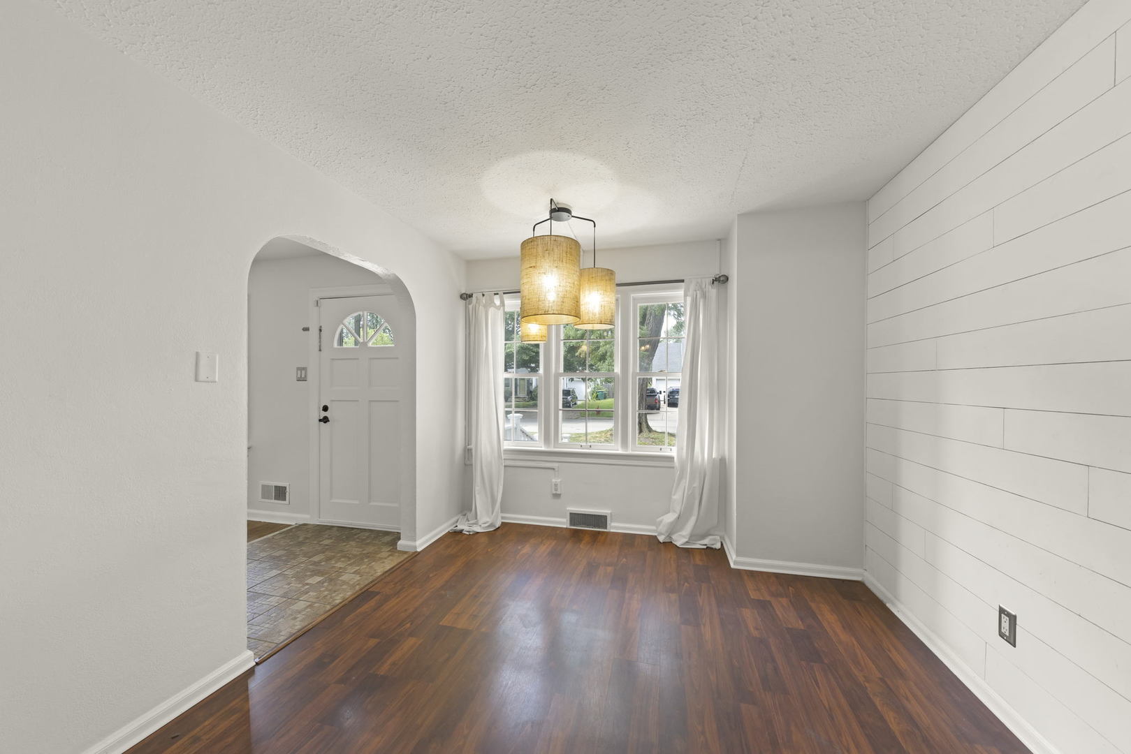 1204 Oneida Street Joliet, IL 60435 - Photo 6 of 30 an empty room with wooden floor chandelier and windows