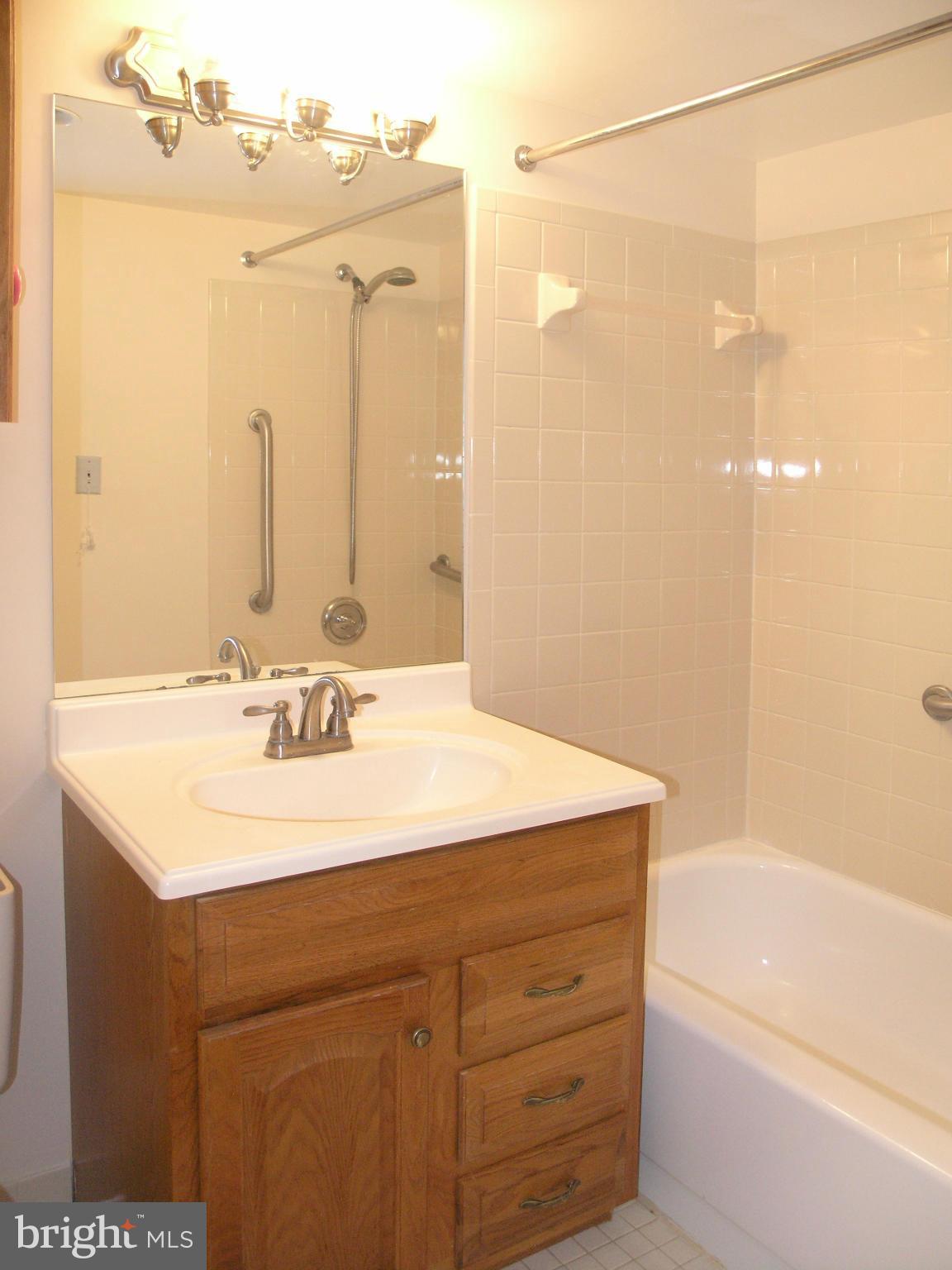 1951 Sagewood Lane, Unit 214 Reston, VA 20191 - Photo 11 of 23 a bathroom with a sink vanity granite tub shower and a mirror